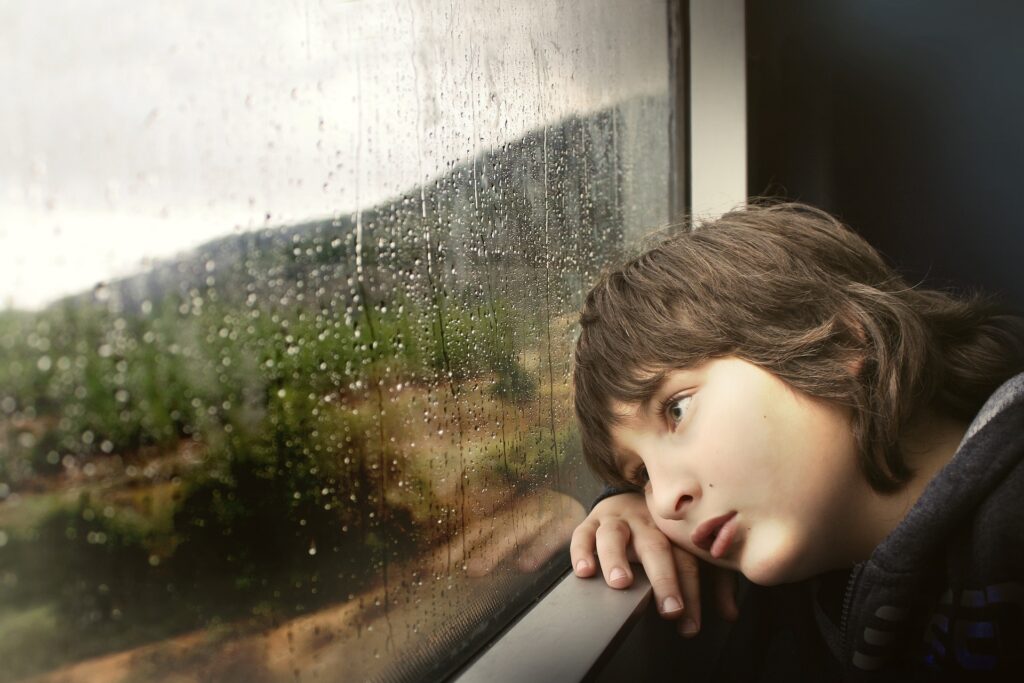 窓の外を見つめる少年